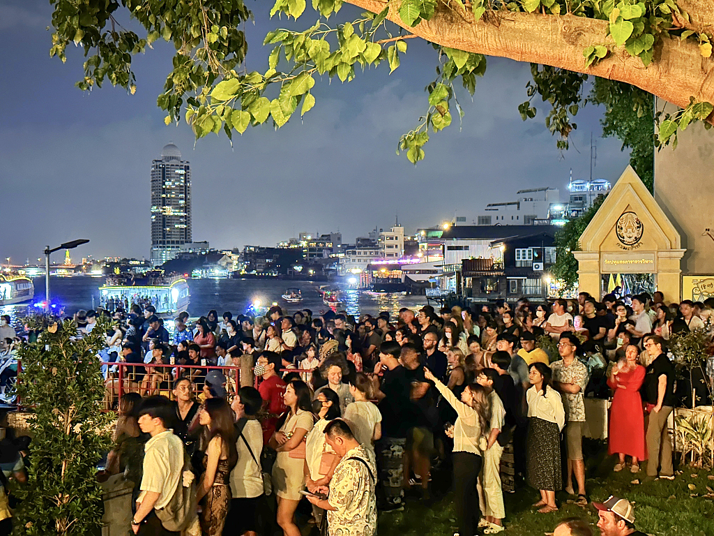 Photo taken on December 31, 2023 shows tourists watching the New Year fireworks from the banks of the Chao Phraya River in Bangkok, Thailand. /CFP