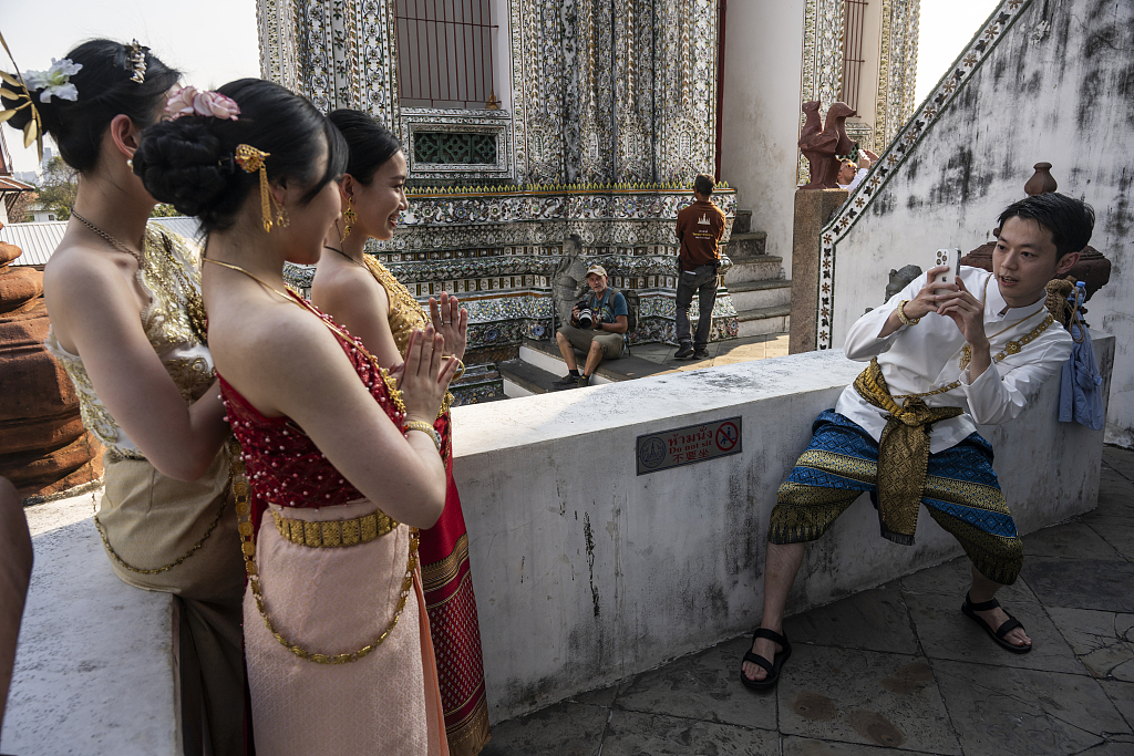 Chinese tourists in traditional Thai dress pose for a photograph in Bangkok, Thailand, on January 17, 2024. /CFP