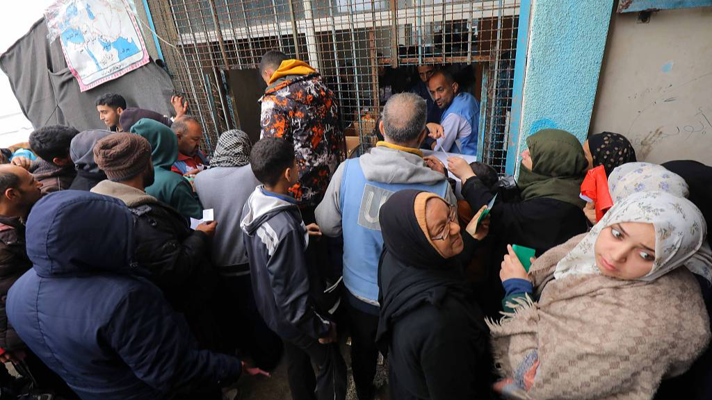 Displaced Palestinians living in a school run by the UN Relief and Works Agency for Palestine Refugees in the Near East gather to get some aid in Deir al-Balah in the central Gaza Strip, January 29, 2024. /CFP