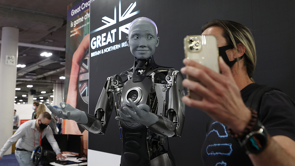 An attendee takes pictures and interacts with the Engineered Arts Ameca humanoid robot with artificial intelligence as it is demonstrated during the Consumer Electronics Show in Las Vegas, Nevada, U.S., January 5, 2022. /VCG