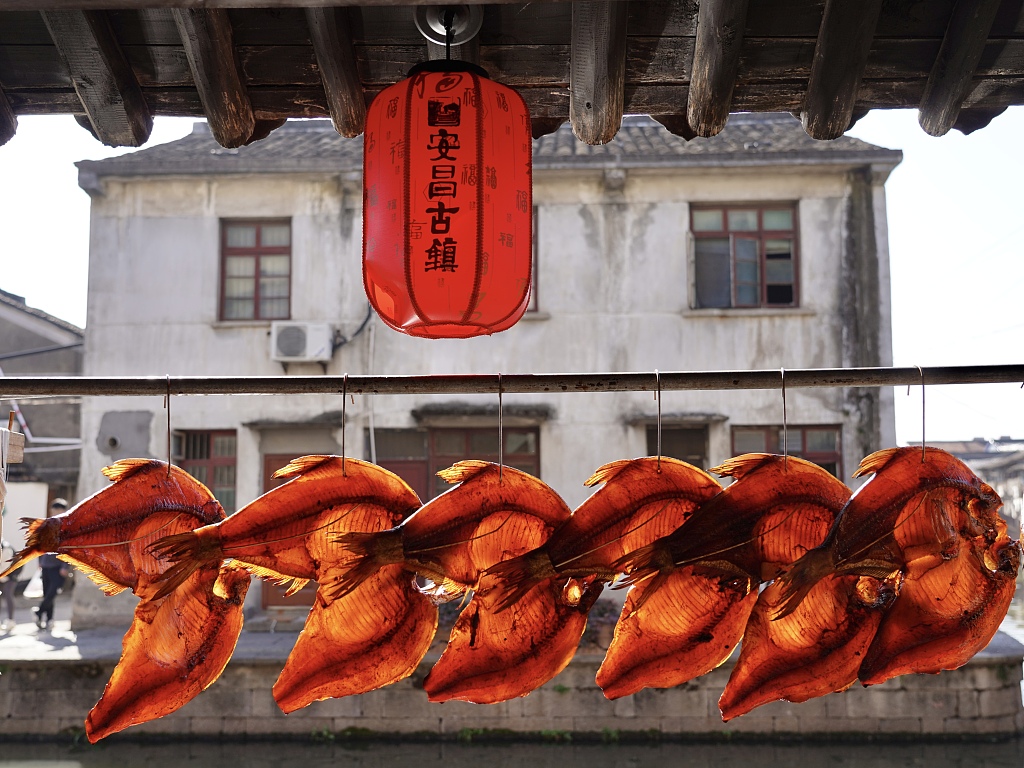 Dried fish are hung alongside a river in Anchang ancient town, Shaoxing, east China's Zhejiang Province, on January 14, 2024. /CFP
