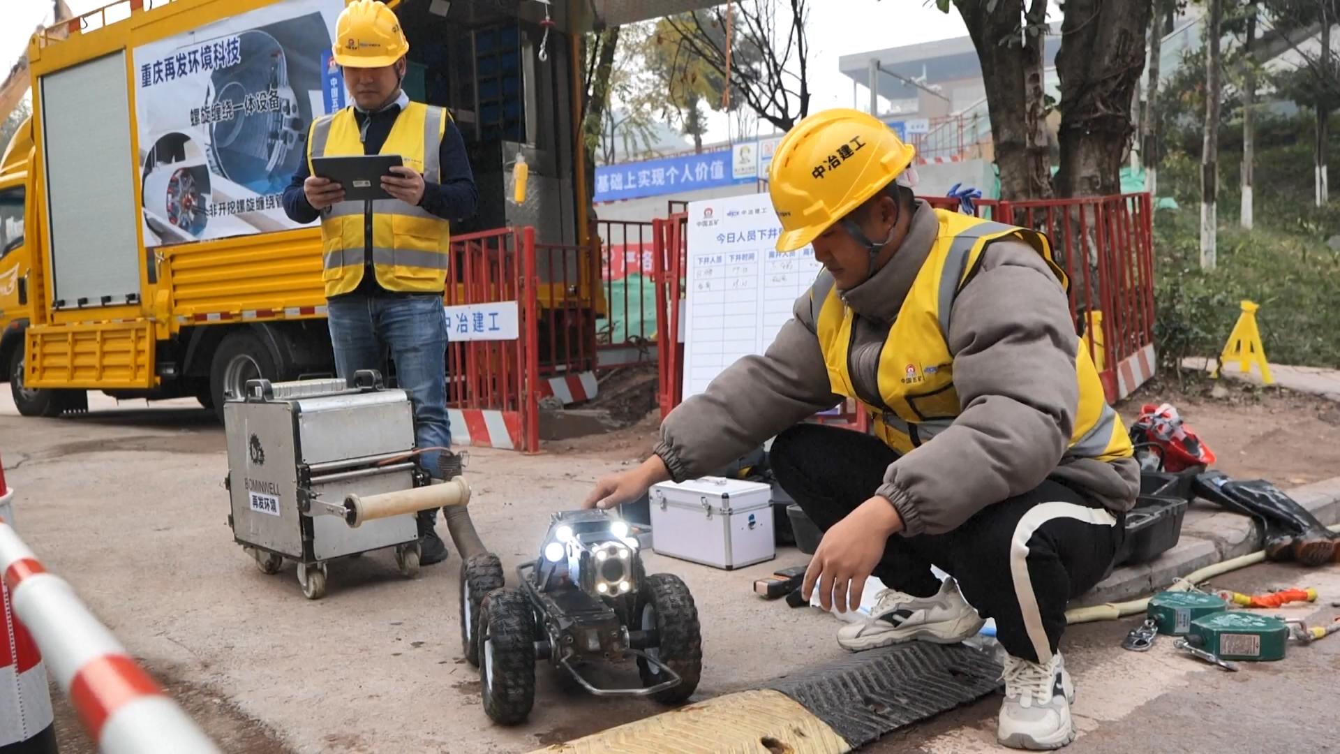 Xia Xiaoyun (R) checks the robot for underground pipeline inspection, southwest China's Chongqing Municipality. /CMG