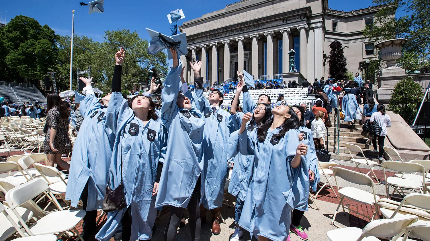 A group of Chinese graduates throw their hats into the sky after the commencement ceremony at Columbia University in New York, May 18, 2016. /Xinhua
