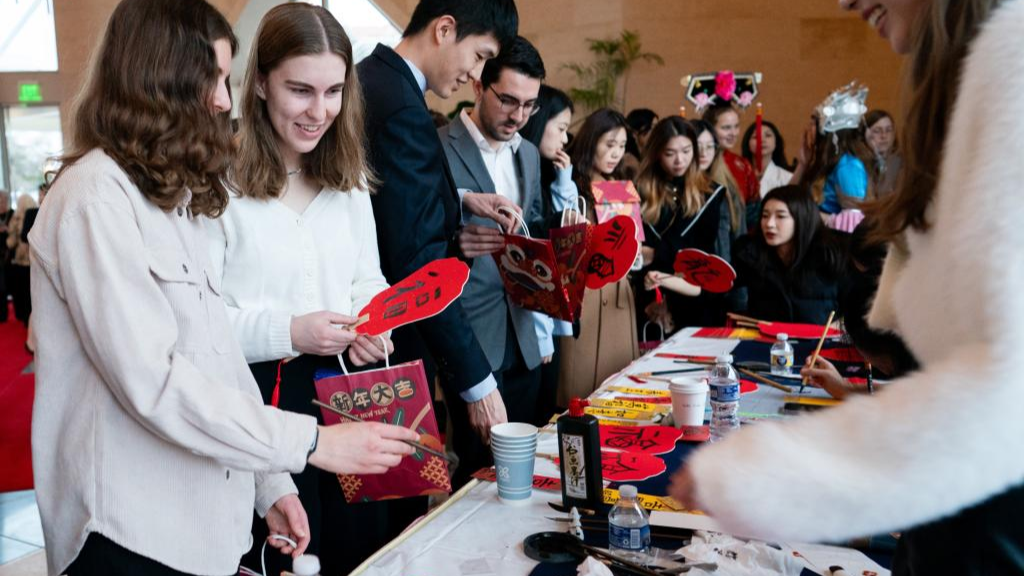 Guests learn to write Chinese calligraphy at an event celebrating the 45th anniversary of China-U.S. student exchanges and the Spring Festival Gala for Chinese and American youths at the Chinese Embassy in Washington, D.C., January 28, 2024. /Xinhua