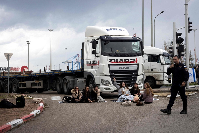 A policemen walks past as Israeli right wing activists block the exit of Ashdod port to stop trucks they claim are carrying humanitarian aid for the Gaza Strip in the coastal city of Ashdod, Israel, February 1, 2024. /CFP