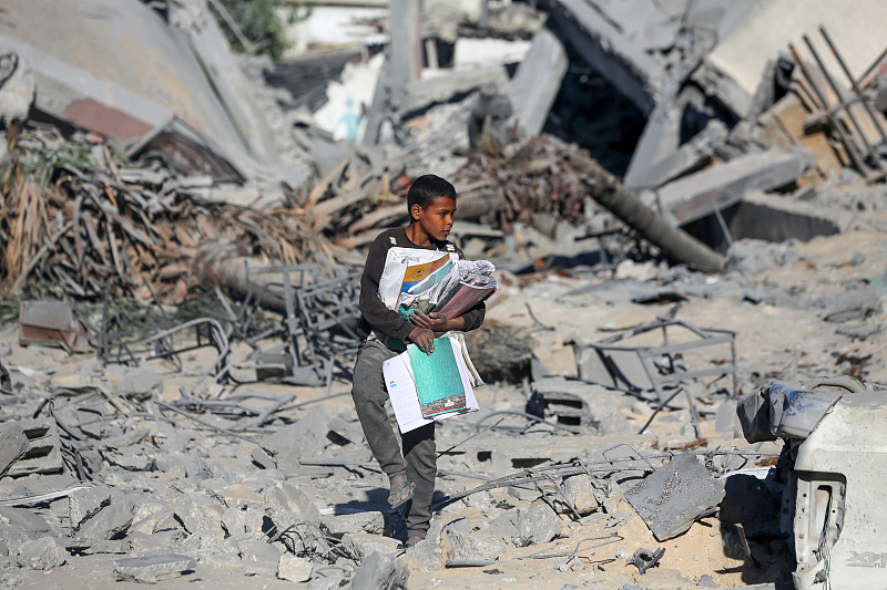 A Palestinian child walks by the rubble of a school, which was targeted overnight by Israeli airstrikes in Nuseirat camp in the central Gaza Strip, January 31, 2024. /CFP