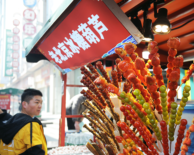 Tanghulu, one of the most popular snacks in China, is seen being sold on a street corner in Weifang City, Shandong Province, January 28, 2024. /CFP