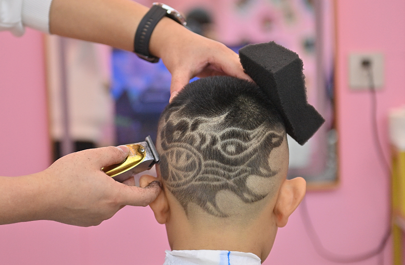 A boy gets a new creative hairstyle at a barbershop in Changchun City, Jilin Province, February 4, 2024. /CFP