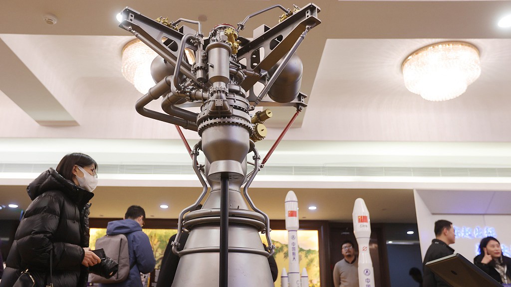 Participants take a look at a rocket engine and rocket models at a conference on commercial aerospace industry development, Beijing, China, February 3, 2024. /CFP