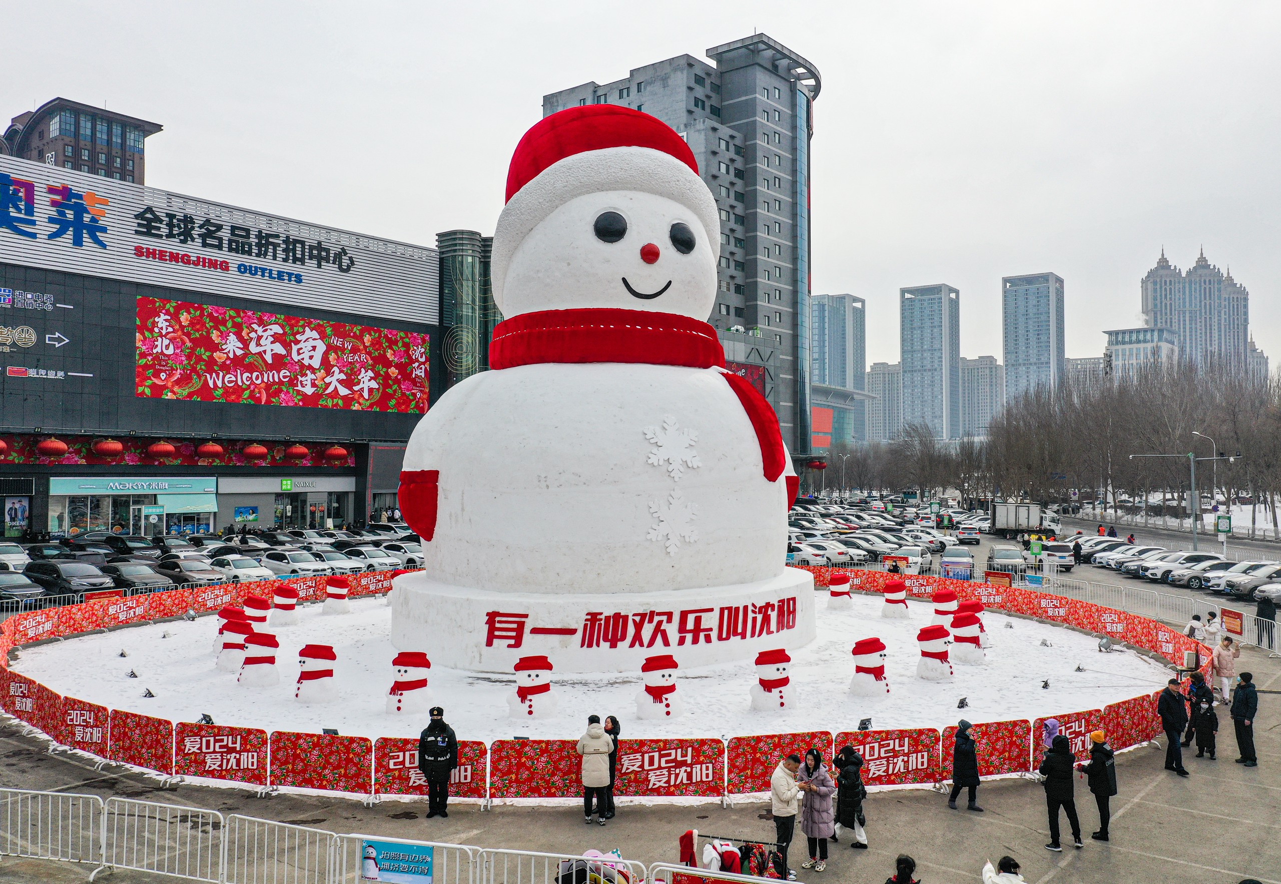 A photo taken on February 5, 2024 shows people taking photos of a snowman installation at a parking lot in Shenyang, Liaoning Province. /IC 