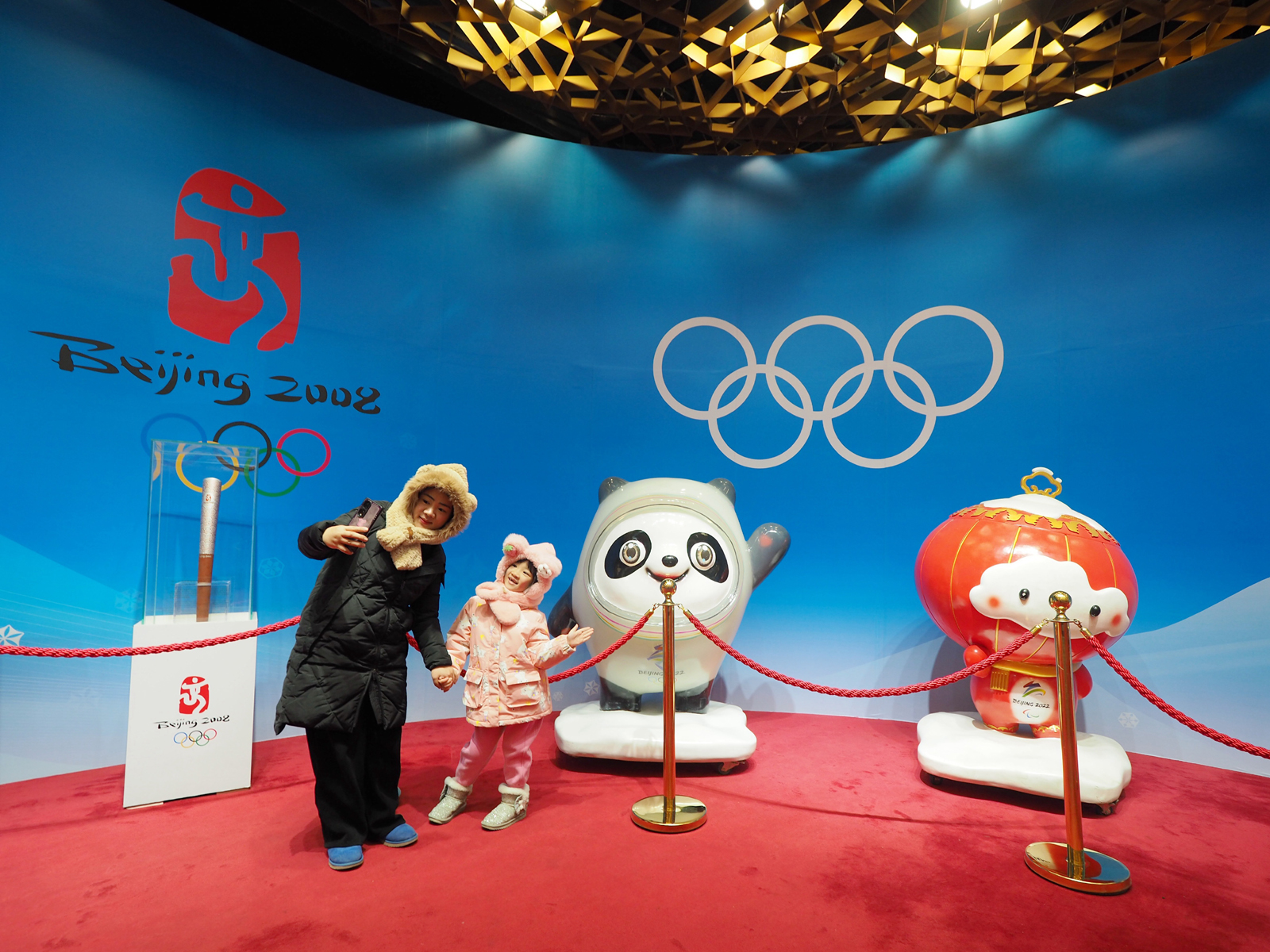 Visitors take a selfie with the Beijing Winter Olympics and Paralympics mascots Bing Dwen Dwen and Shuey Rhon Rhon at an exhibition at the National Stadium in Beijing on February 5, 2024. /IC