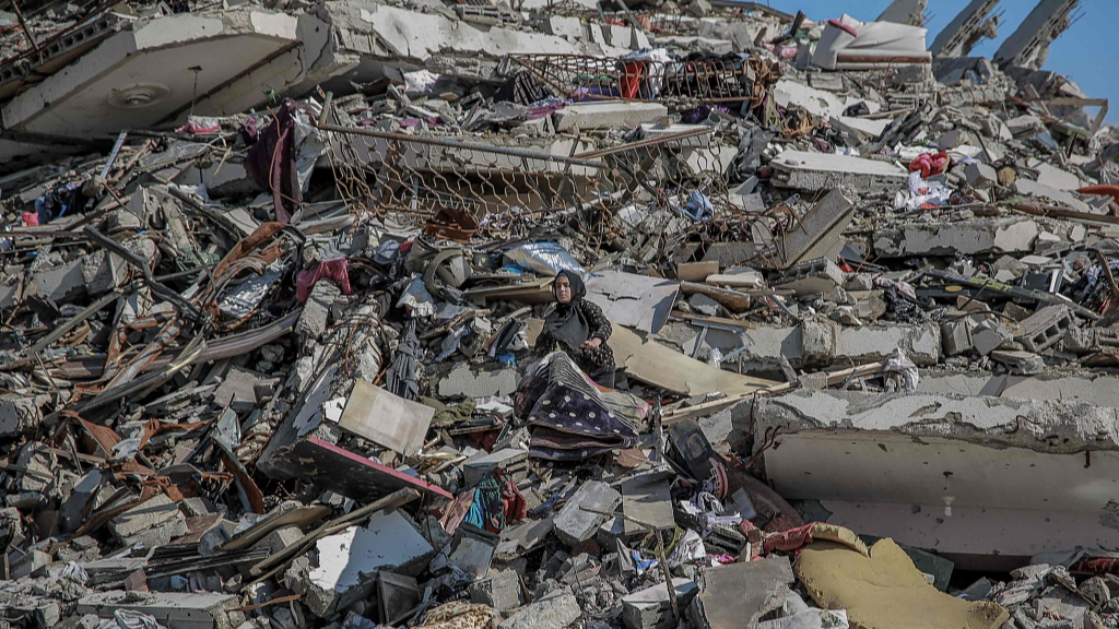 A woman searches for salvageable items amid the rubble of buildings destroyed during Israeli bombardment on Al-Mukhabarat street in Gaza,  February 3, 2024. /CFP