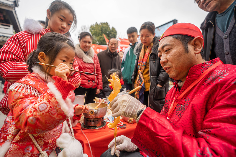 A vendor creates blown-sugar figurines for children on a street in Bijie City, Guizhou Province, February 3, 2024. /CFP