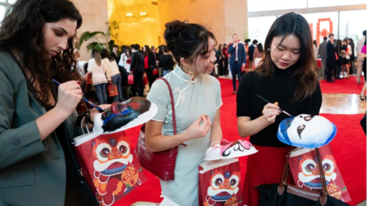 Guests try painting Peking Opera masks at an event celebrating the 45th anniversary of China-U.S. student exchanges and the Spring Festival Gala for Chinese and American youths at the Chinese Embassy in Washington, D.C., U.S., January 28, 2024. /Xinhua