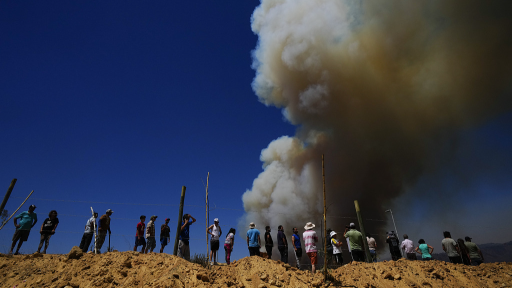 Residents watch as a plume of smoke from wildfires rise into the sky, in Vina del Mar, Chile, February 3, 2024. /CFP