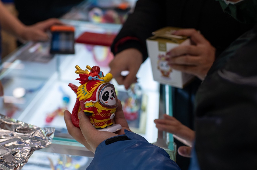 A photo shows a shopper holding a new Loong Dwen Dwen figurine in Beijing on February 5, 2024. /IC