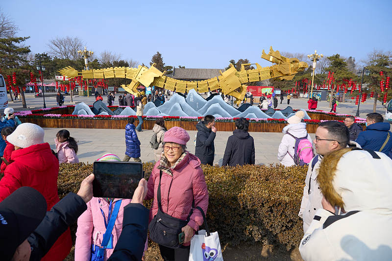 People flock to the Old Summer Palace to take photos of a giant golden 