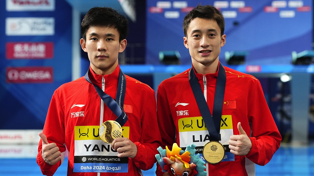 China's Yang Hao (L) and Lian Junjie hold up their gold medals after the men's synchronized 10m platform diving final at the World Aquatics Championships in Doha, Qatar, February 8, 2024. /CFP