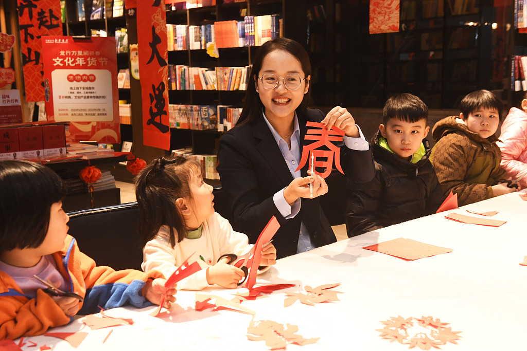 A teacher teaches children how to make a papercut, a traditional custom during the Spring Festival, in Shijiazhuang, north China's Hebei Province, February 6, 2024. /CFP