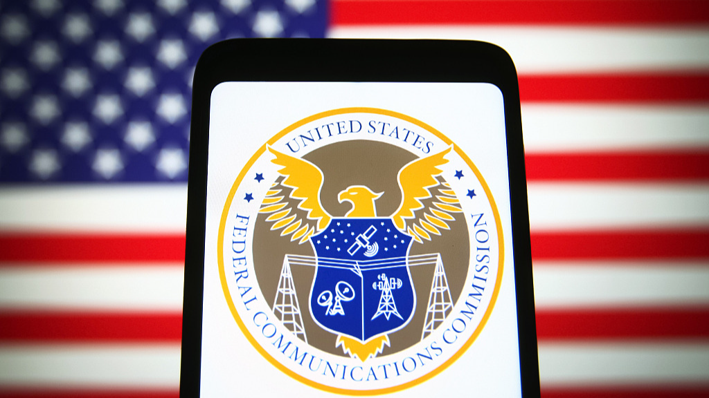 An illustration shows U.S. Federal Communications Commission (FCC) seal on a smartphone screen with the U.S. national flag in the background. /CFP