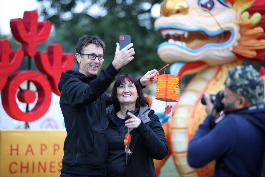 Tourists take selfies in front of a dragon-shaped installation to welcome the Chinese Lunar New Year at Hagley Park in Christchurch, New Zealand, February 9, 2024. /Xinhua