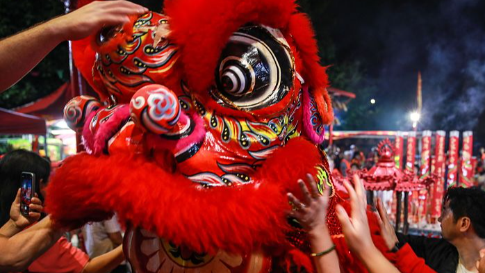 People interact with a lion dance during Chinese Lunar New Year's Eve celebration at Sze Yup Kwan Ti temple in Sydney, Australia, February 9, 2024. /CFP