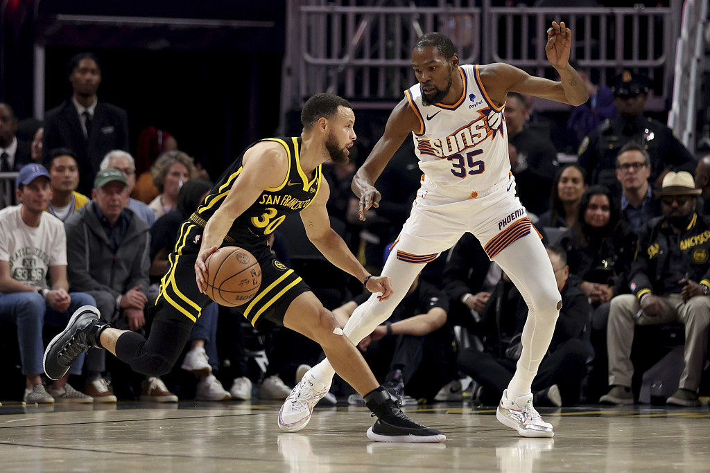 Stephen Curry (R) of the Golden State Warriors dribbles to dodge Kevin Durant of the Phoenix Suns in the game at the Chase Center in San Francisco, California, February 10, 2024. /CFP
