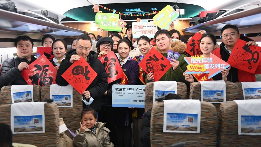 Passengers and staff members pose for a group photo on the first bullet train heading directly for Guangzhou East Railway Station in south China's Guangdong Province from Hangzhou West Railway Station in Hangzhou City of east China's Zhejiang Province, January 10, 2024. /Xinhua