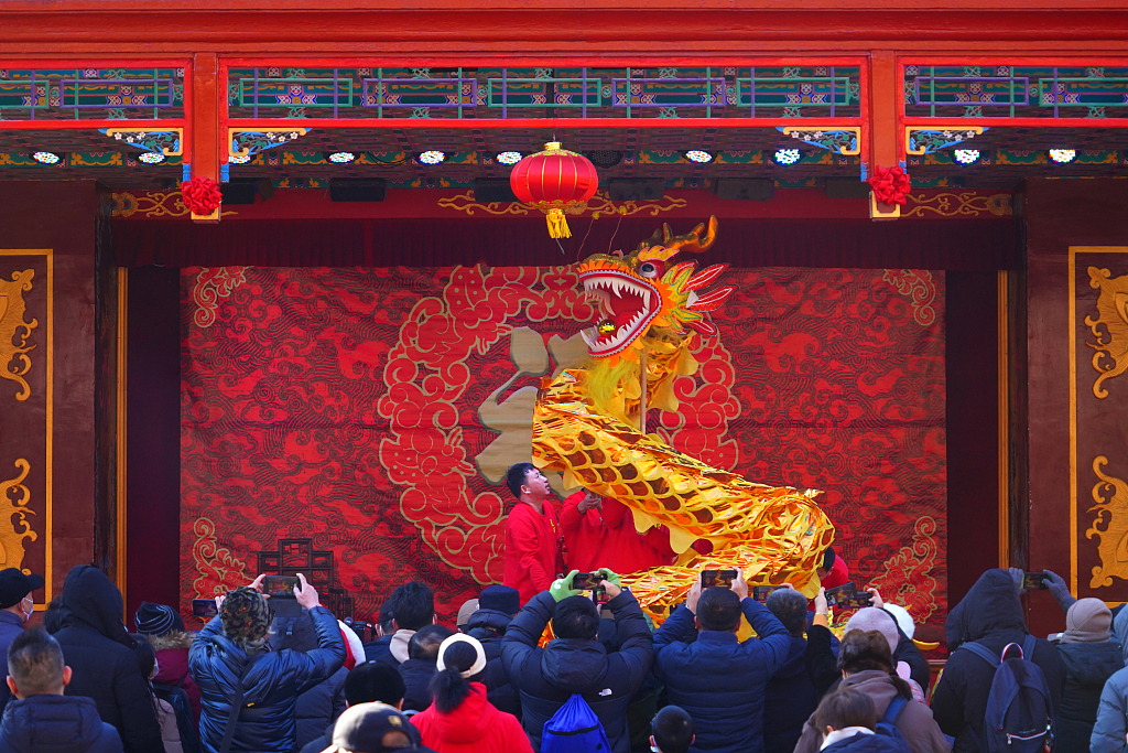 Visitors watch a dragon dance at the temple fair at Daguanyuan, or Grand View Garden, in the Xicheng District of Beijing on February 10, 2024, Chinese New Year's Day. /CFP