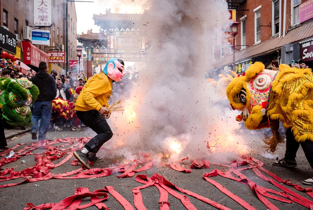 People set off firecrackers as a lion dance is performed in Chinatown to celebrate the Chinese New Year in Philadelphia, Pennsylvania, United States on February 11, 2024. /CFP