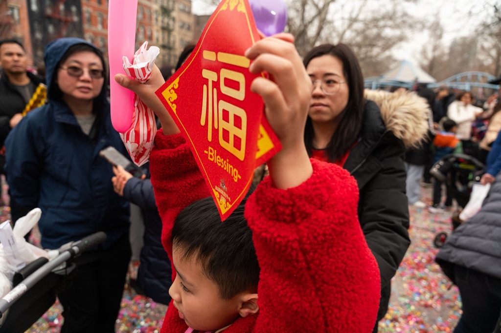 A child holds up the Chinese character 