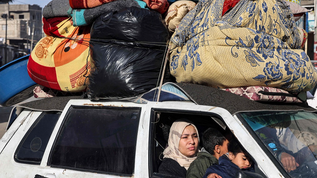 Members of a Palestinian family ride in a vehicle carrying their belongings as they flee Rafah in the southern Gaza Strip, February 12, 2024. /CFP