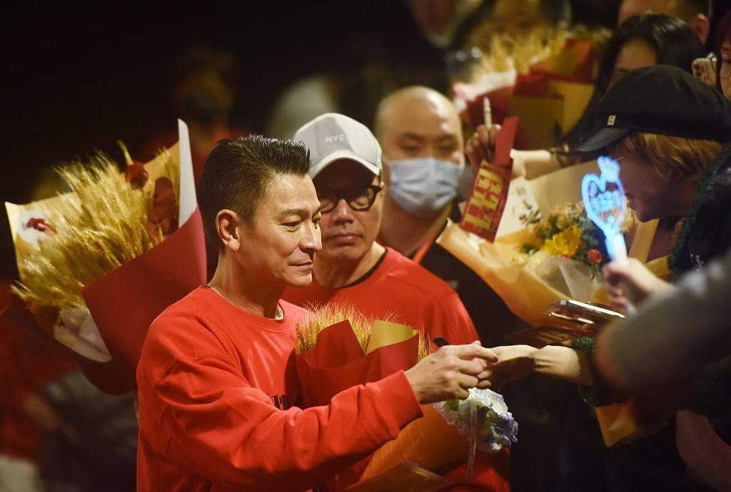 Andy Lau (left) dressed in red, promotes his latest film 