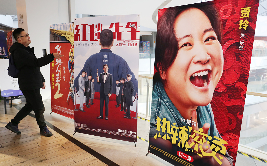 A movie fan checks out posters promoting the latest blockbusters at a cinema in Shanghai, February 10, 2024. /CFP