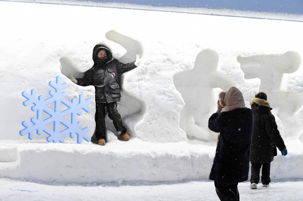 A photo shows a person posing in a snow carving at Harbin Ice and Snow World in Harbin, Heilongjiang Province, February 14, 2024. /CFP