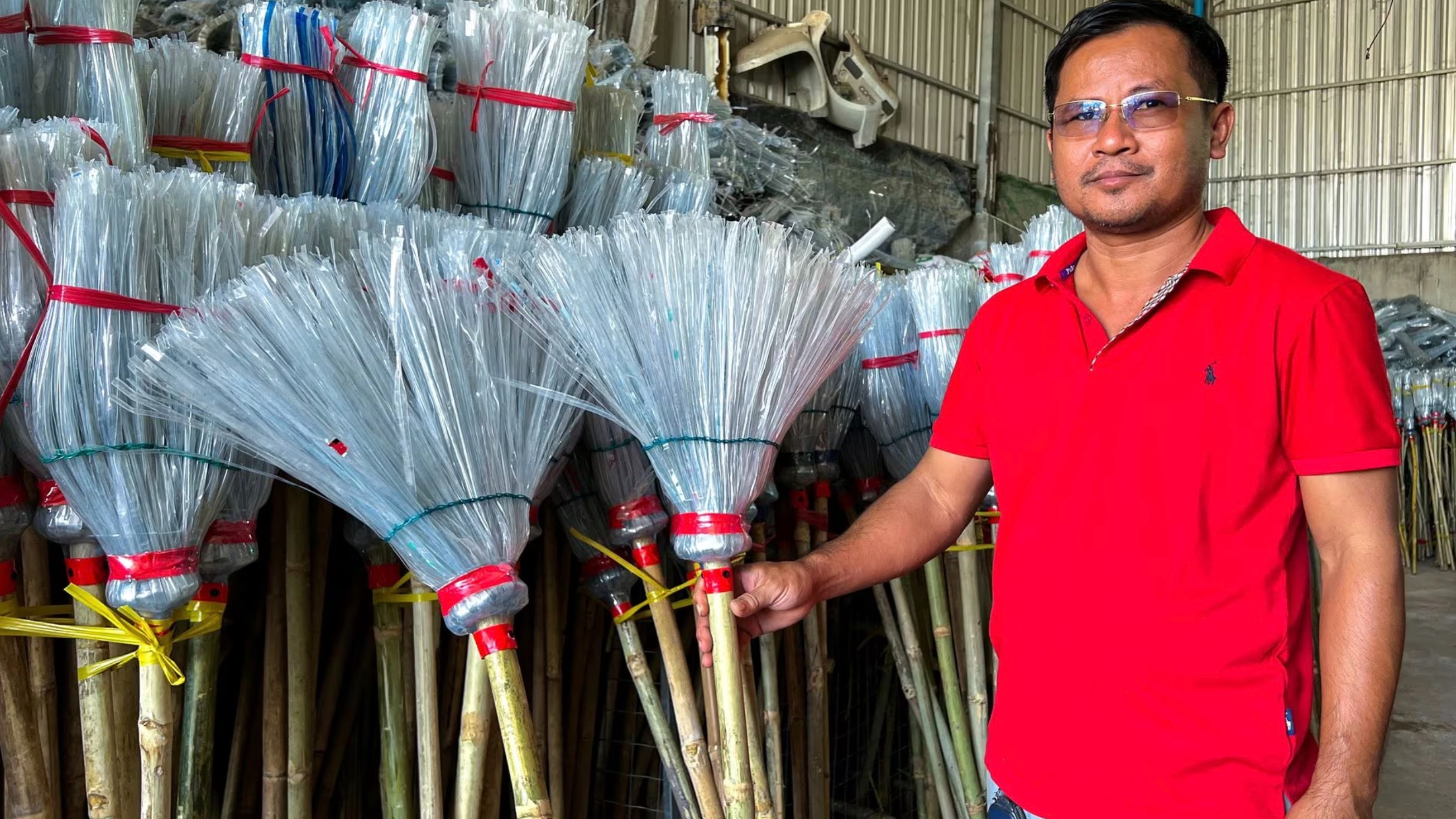 Has Kea poses next to plastic broomsticks at a warehouse in Phnom Penh, Cambodia, January 15, 2024. /CFP