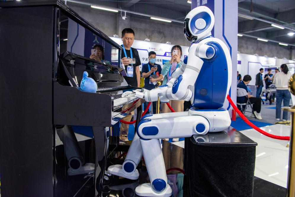 Attendees watch a robot playing the piano at the 8th China Robotop and Intelligent Economic Talents Summit in Yuyao City, east China's Zhejiang Province, May 24, 2023. /Xinhua