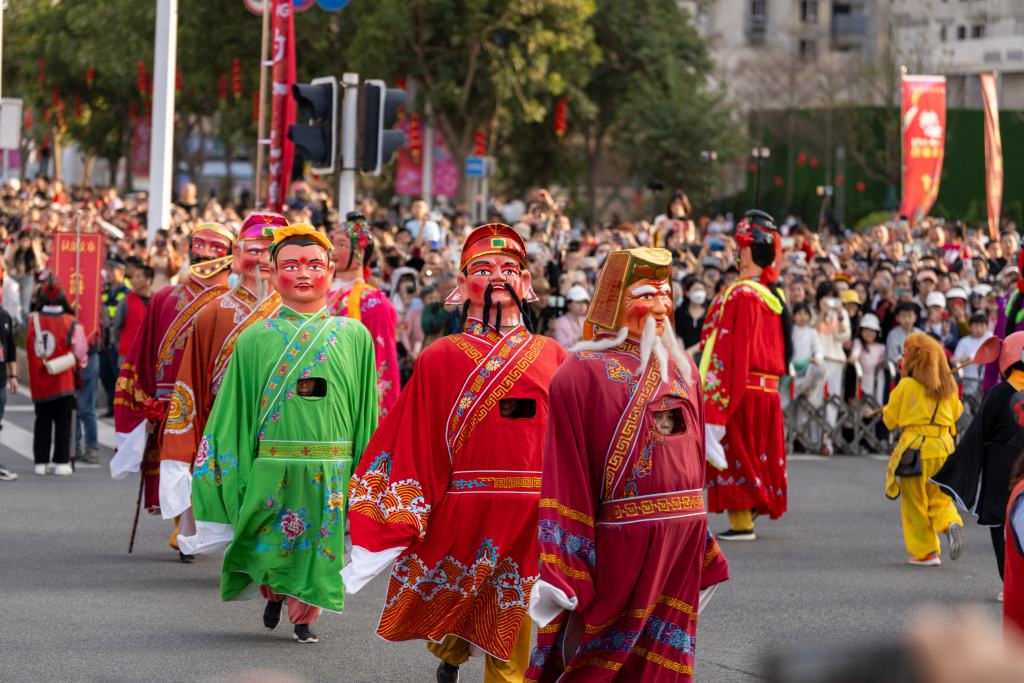 Performers wearing costumes of Chinese mythological figures walk during the festive parade 