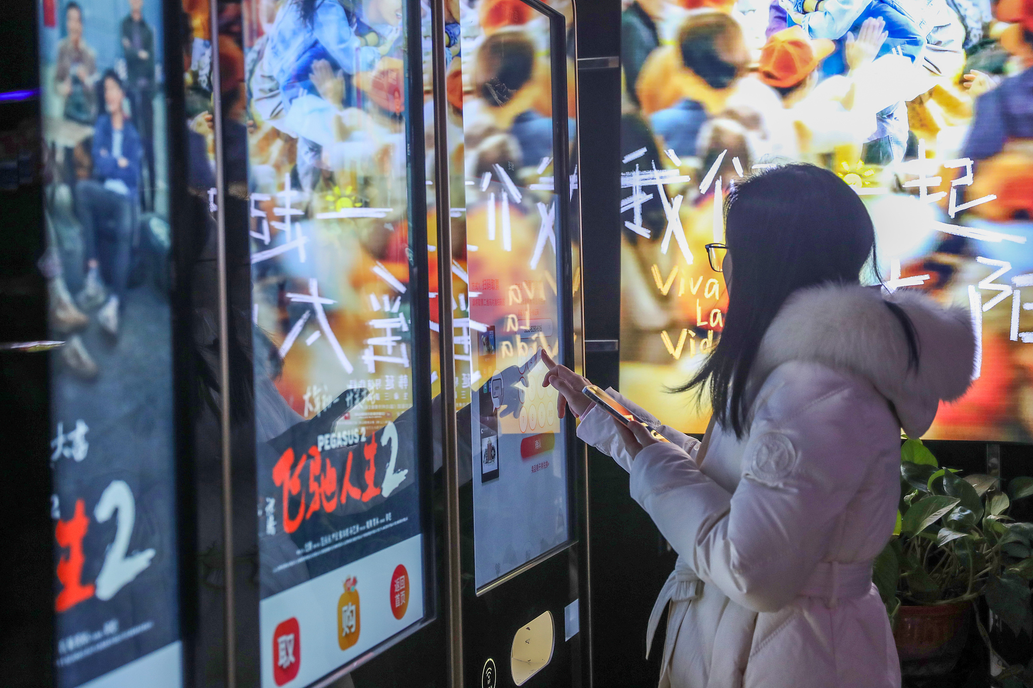 A moviegoer collects tickets from an automatic vending machine at a theater in Yangzhou, east China's Jiangsu Province, February 16, 2024. /CFP