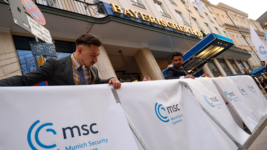 Workers cover security barriers with a branded banner on the opening day of the Munich Security Conference in Munich, Germany, February 16, 2024. /CFP

