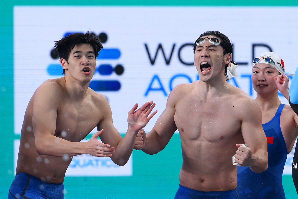 L-R: Pan Zhanle, Wang Haoyu and Li Bingjie of China celebrate while Yu Yiting (not pictured) in action in the mixed 4x100m freestyle relay final during the World Aquatics Championships in Doha, Qatar, February 17, 2024. /CFP