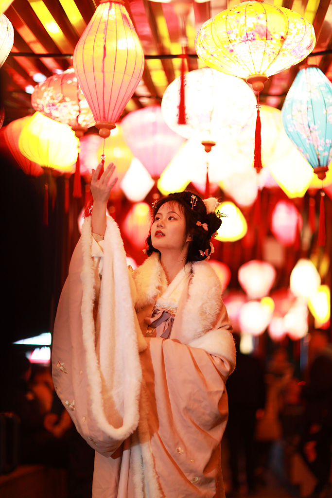 A young woman dressed in traditional Chinese costume poses for photos at a lantern fair in Yichang, Hubei Province on February 15, 2024. /CFP