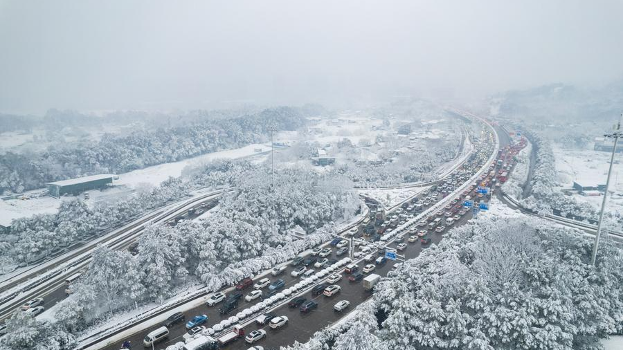 An aerial drone photo shows vehicles running on the road during snowy weather in Changsha, central China's Hunan Province, January 22, 2024. /Xinhua
