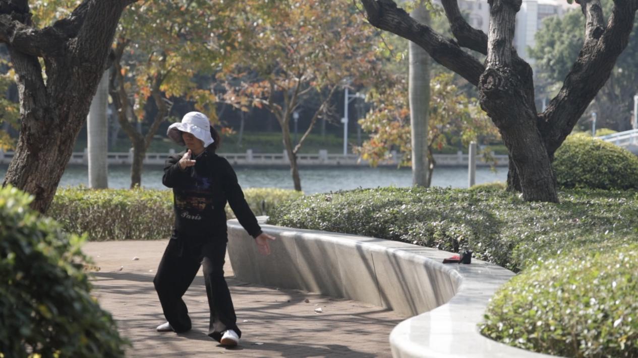 A woman practices Tai Chi at Bailuzhou Park (Egret Island Park) in Xiamen, southeast China's Fujian Province. /CGTN