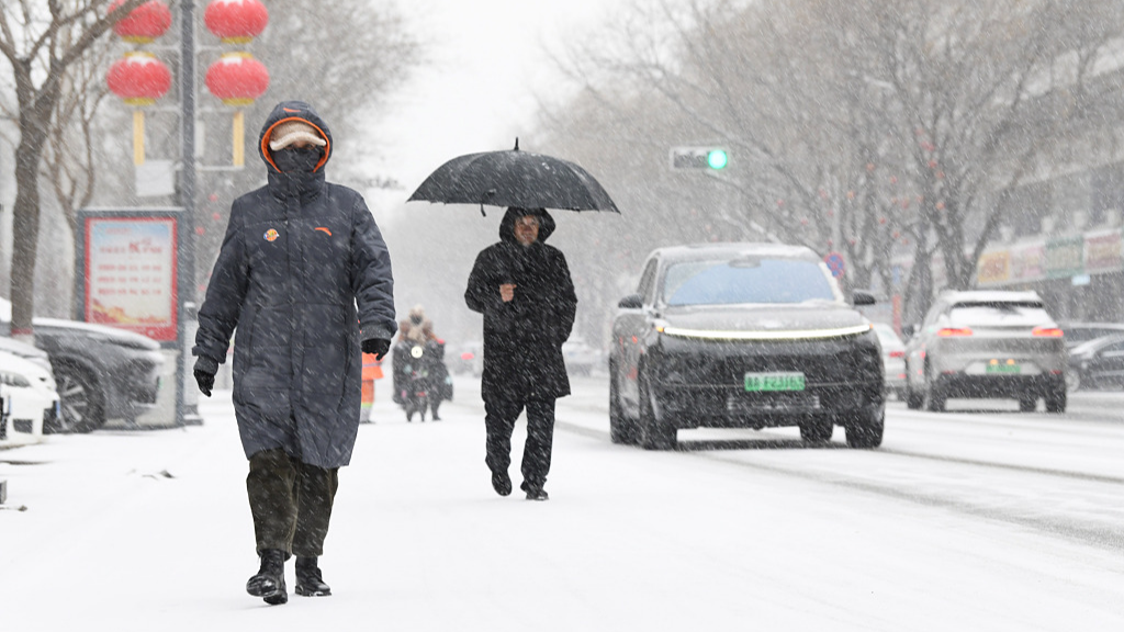People walk on a snowy street in north China's Hebei Province, February 20, 2024. /CFP