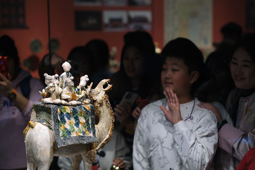 Photo taken on February 14, 2024 shows visitors appreciating the tricolored pottery camel figurine on display at the Shaanxi History Museum in Xi'an, Shaanxi Province. /CFP