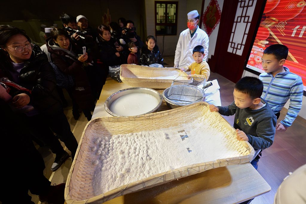 Pupils learn how to make tangyuan at a cultural experience event in Beijing on February 20, 2024. /CFP