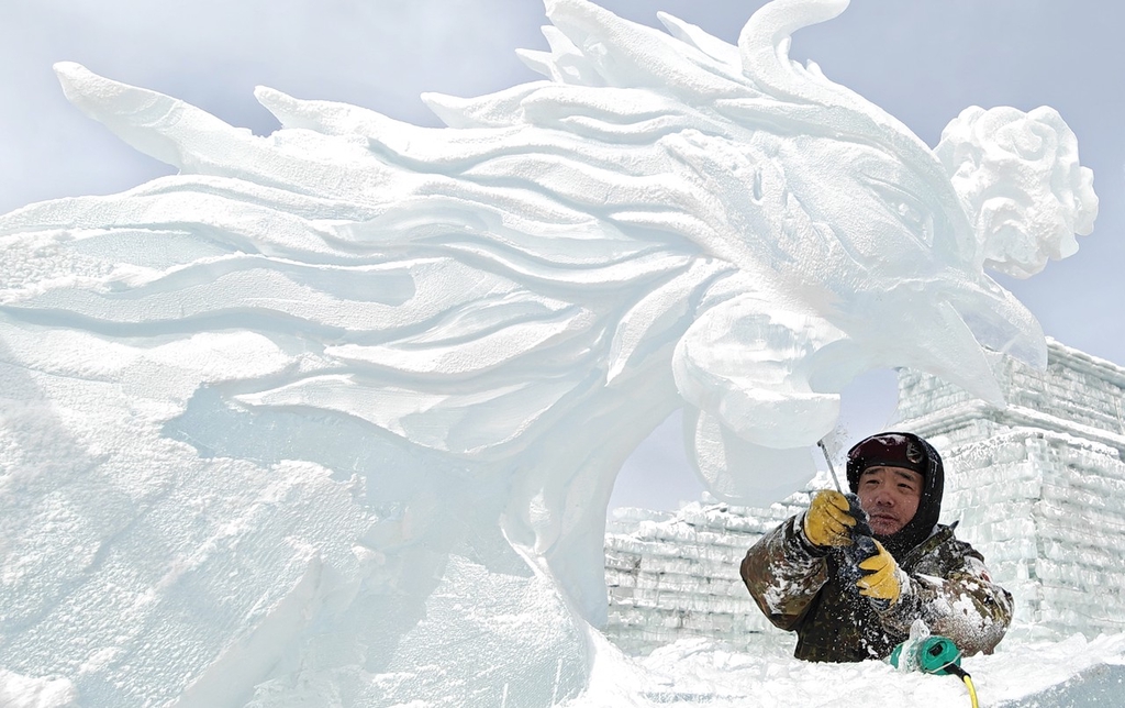 A sculptor carves an ice work in Changchun, northeast China's Jilin Province, February 20, 2024. /IC