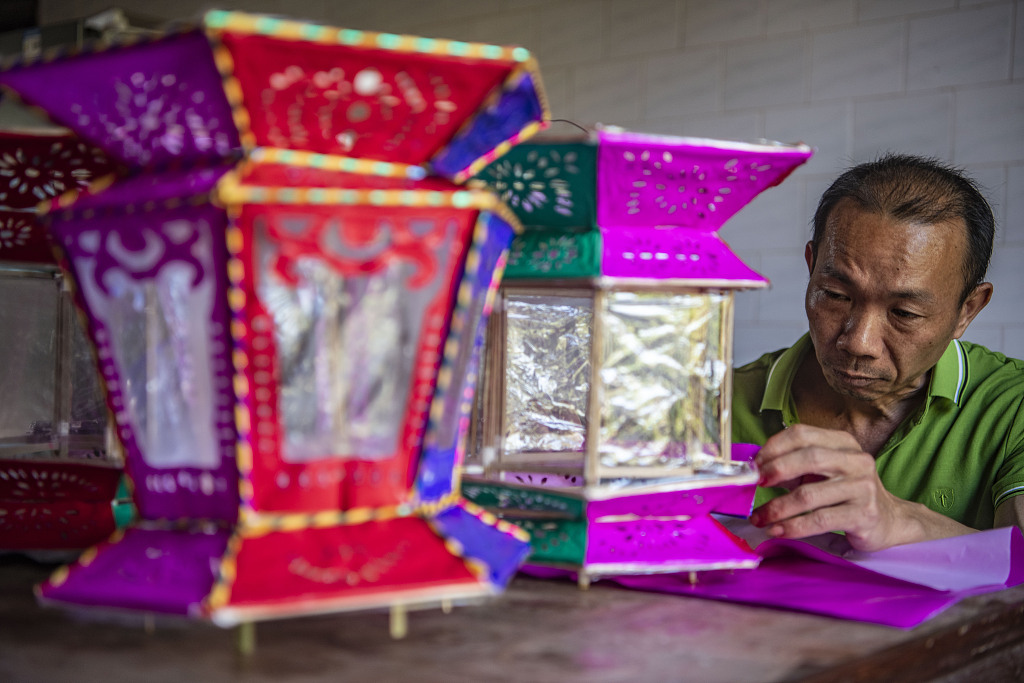A craftsman puts the finishing touches to a lantern in Qionghai, south China's Hainan Province, February 21, 2024. /CFP