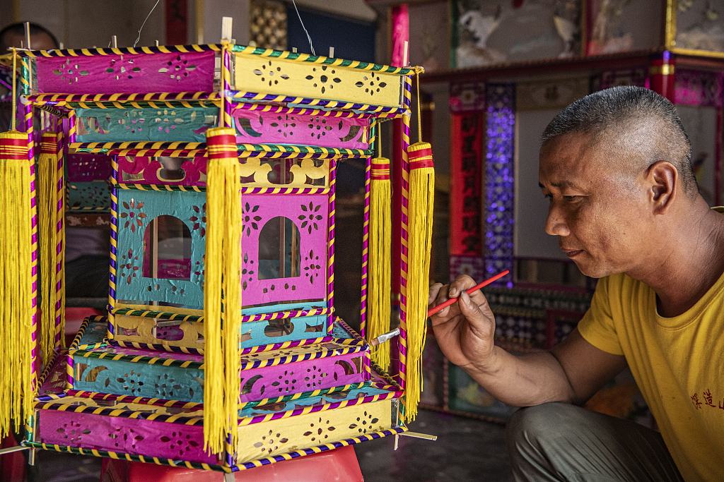 A craftsman puts the finishing touches to a lantern in Qionghai, south China's Hainan Province, February 21, 2024. /CFP